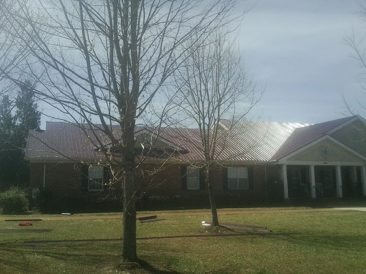 Red metal roof on a brick building seen from the front lawn in Patuxent River
