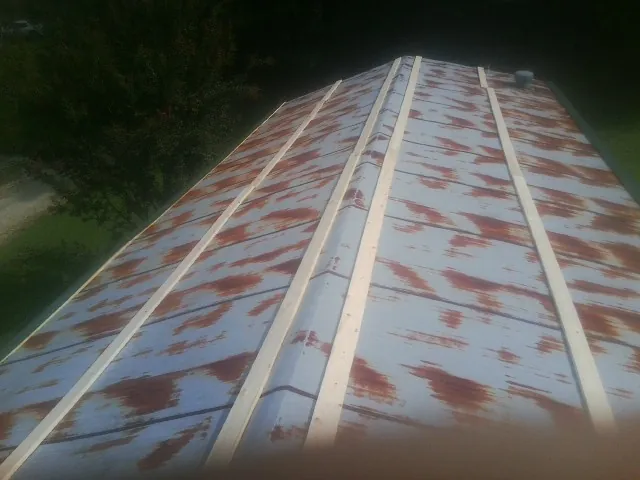Rusted metal roof panels with new wood purlins before replacement — Storm Damage Roof Repair in Patuxent River by Roofing Brothers